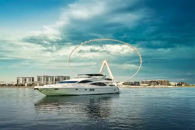 A luxury yacht docked in front of a Ferris wheel, showcasing Deep Sea Cruising in Abu Dhabi's vibrant waterfront.